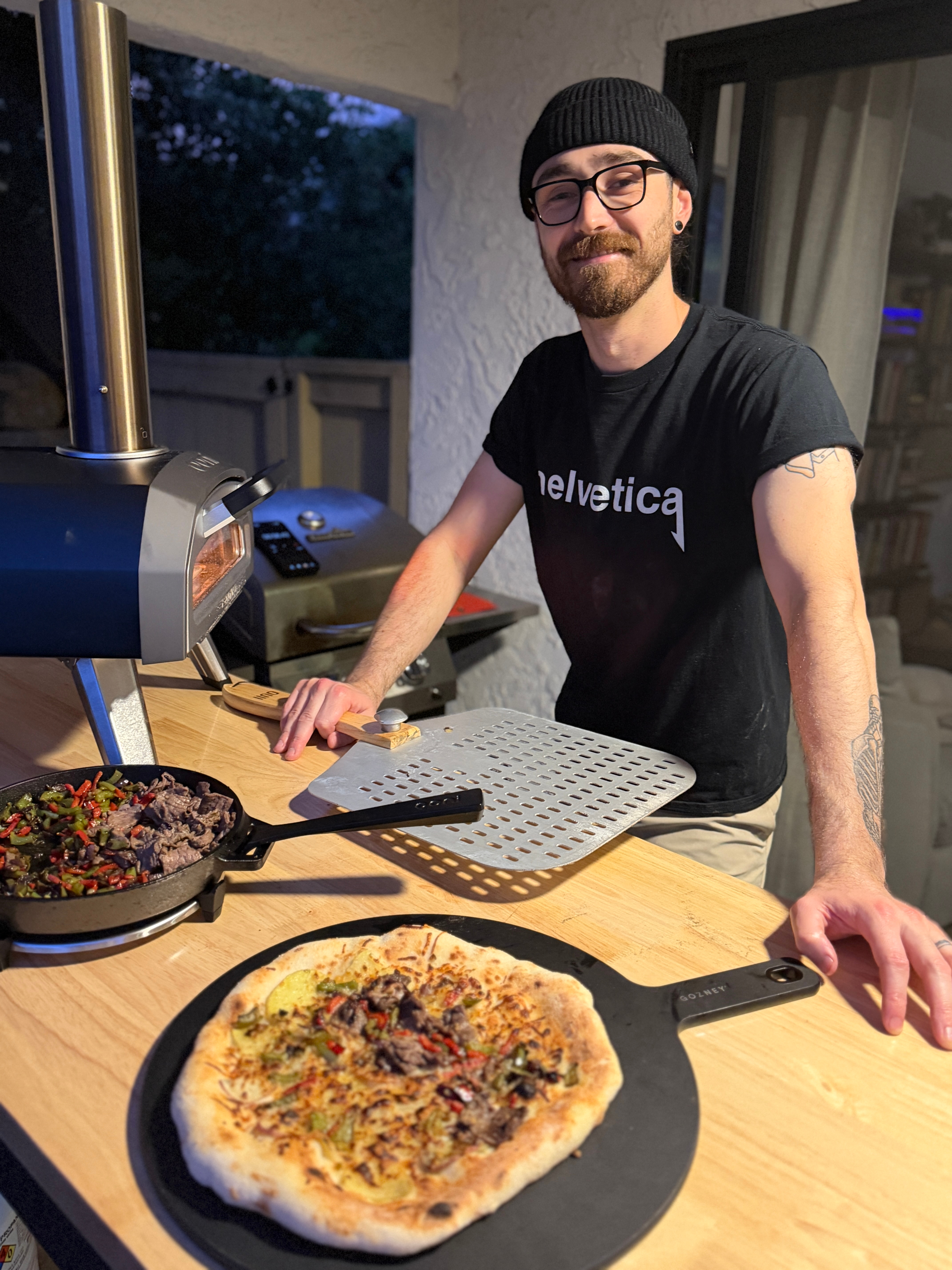 Dillon Hickey making pizza wearing a Helvetica Tshirt